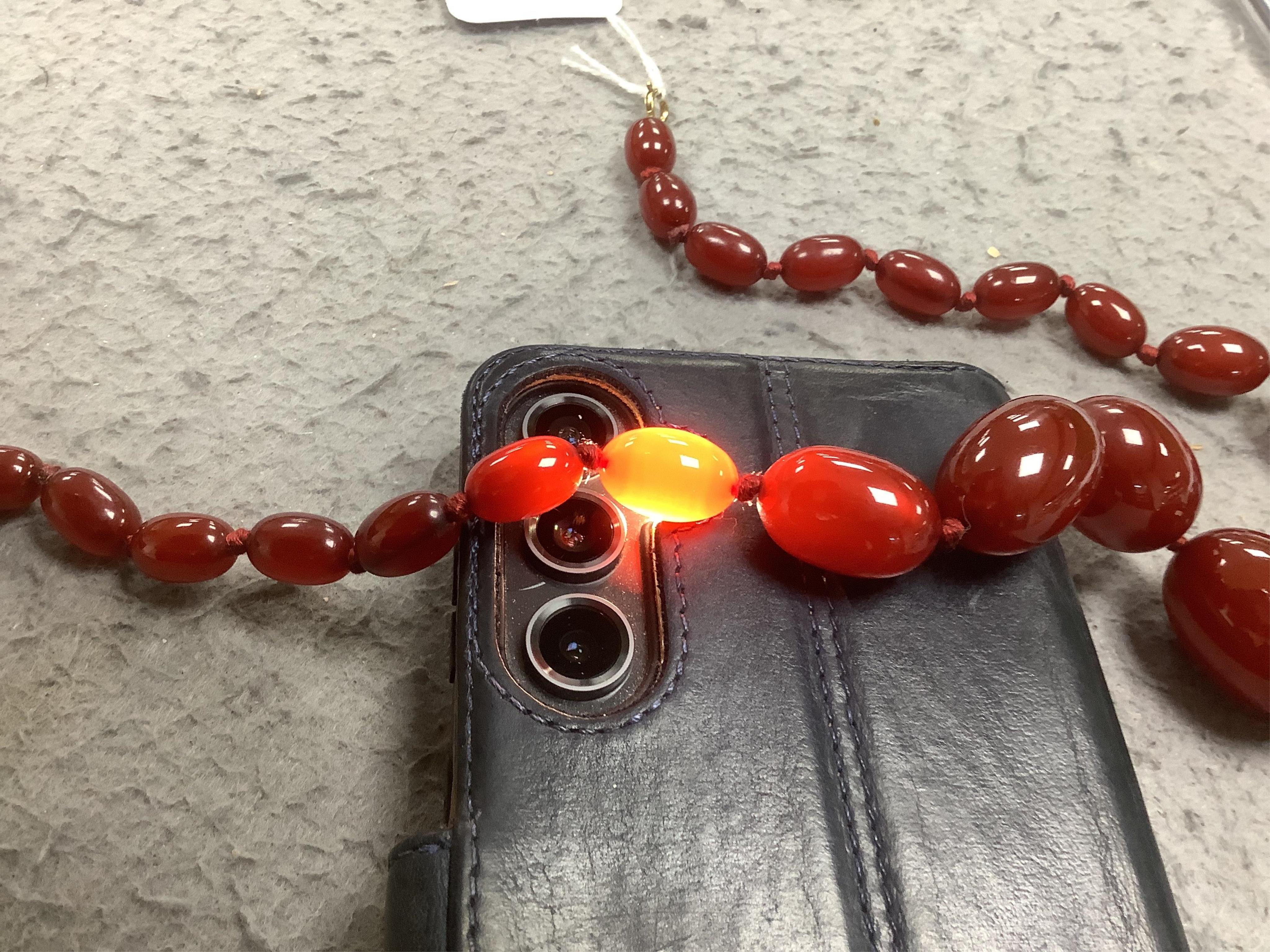 A single strand graduated simulated cherry amber necklace, 46cm, gross weight 58 grams. Condition - fair to good